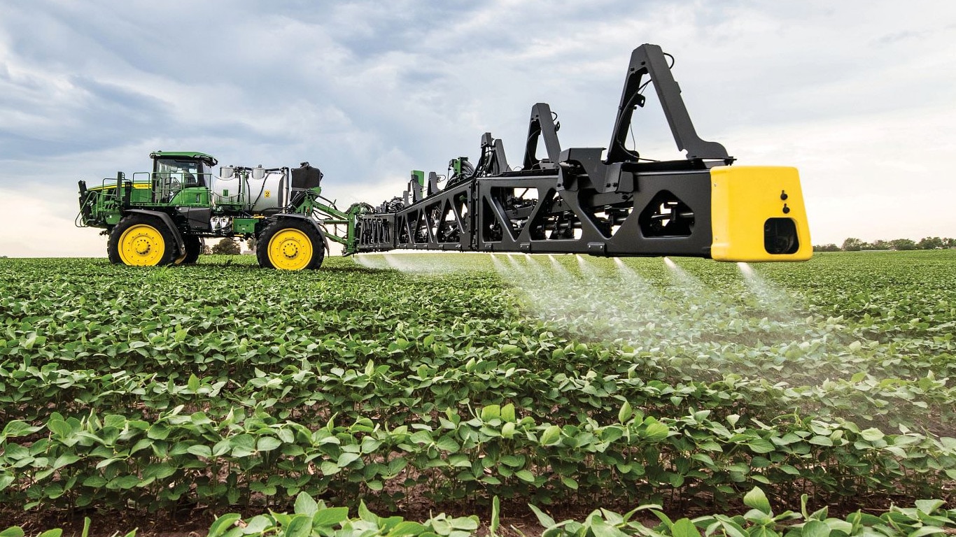 Primo piano del braccio di una irroratrice John Deere in un campo aperto.