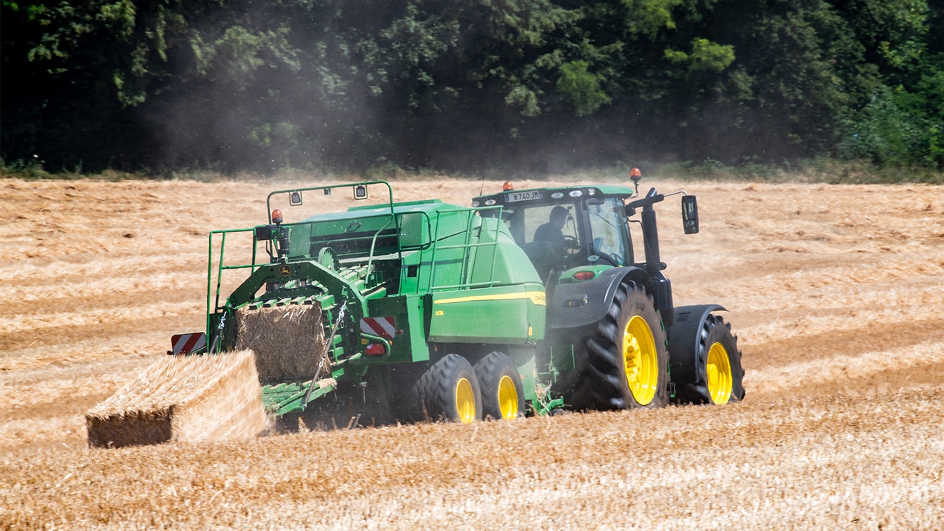 Pressa per balle quadre giganti John Deere L634 con trattore 6R per raccolti di paglia